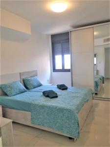 - une chambre dotée d'un lit avec des draps bleus et un miroir dans l'établissement 4bdrm - 110mr - Dream vacation apartment, à Tibériade