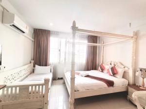 a bedroom with two beds and a canopy bed at 39 Living in Bangkok