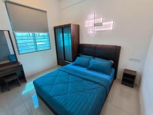 a bedroom with a blue bed and a television at Homestay Naufal Bandar Sri Sendayan Ground Floor in Seremban