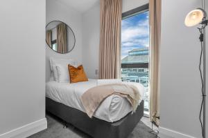 - une chambre avec un lit et une grande fenêtre dans l'établissement Bachelor's Sunset Pad, à Auckland