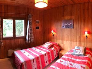 two beds in a bedroom with wooden walls and a window at Chalet Bernex, 5 pièces, 10 personnes - FR-1-498-94 in Bernex