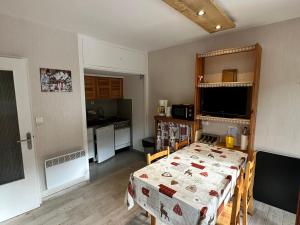 a room with a table and a kitchen at Studio Villard-de-Lans, 1 pièce, 4 personnes - FR-1-515-179 in Villard-de-Lans