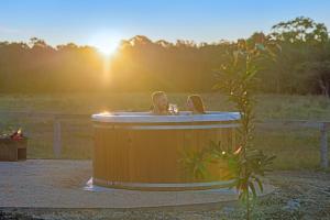 a man and a woman sitting in a hot tub at Waratah @ The Beltree in Belford