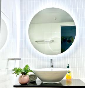 Baño blanco con lavabo y espejo en Ocean and beach View, en Gold Coast