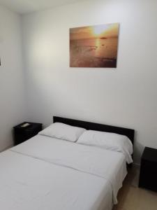 ein Schlafzimmer mit 2 Betten und einem Bild an der Wand in der Unterkunft CASA RODADERO SANTA MARTA in Santa Marta