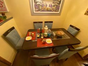 a dining room table with chairs and a table with food on it at My Way GUEST HOUSE in Cusco