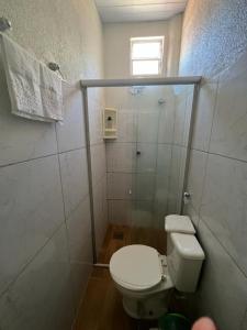 a small bathroom with a toilet and a shower at Pousada da Celma in Fortaleza