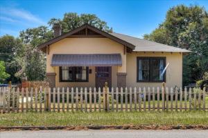 una pequeña casa amarilla con una valla blanca en Noble Cottage 3 Bed 1 Bath, en Augusta