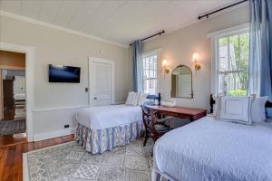 1 dormitorio con 2 camas, escritorio y ventana en Noble Cottage 3 Bed 1 Bath, en Augusta