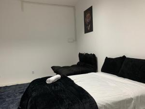 a bedroom with a bed and a black couch at Studio 308 - Apartamento Passo Fundo in Passo Fundo