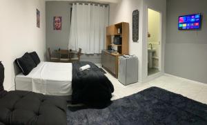 a bedroom with a bed and a tv in it at Studio 308 - Apartamento Passo Fundo in Passo Fundo +3 photos