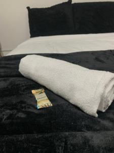 a white towel laying on a black blanket on a bed at Studio 308 - Apartamento Passo Fundo in Passo Fundo