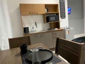 a table and chairs with a table and a kitchen at Studio 308 - Apartamento Passo Fundo in Passo Fundo