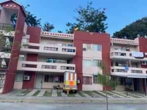 un immeuble d'appartements avec un rouge et un blanc dans l'établissement Departamento en Pomoca, à Palenque