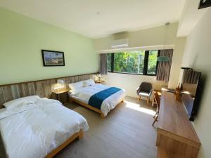 a hotel room with two beds and a desk and a desk at Taroko 767 Farm B&B 太魯閣767農莊民宿 in Xiulin
