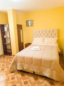 a large white bed in a room with yellow walls at Pretty room in front of the Lima Airport in Lima