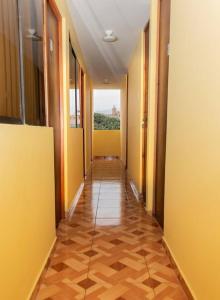 a hallway with yellow walls and a tile floor at Pretty room in front of the Lima Airport in Lima
