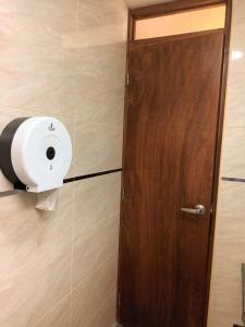 a door with a roll of toilet paper on a wall at Pretty room in front of the Lima Airport in Lima