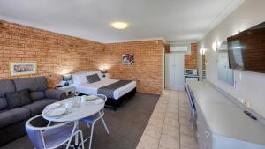 pokój hotelowy z łóżkiem i kanapą w obiekcie Blue Diamond Motor Inn w mieście Dubbo