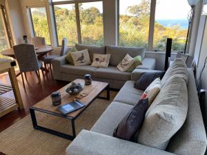 sala de estar con sofá y mesa en Paradise on the Hill ~ Tuateawa, 