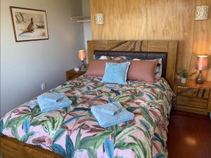a bedroom with a bed with towels on it at Paradise on the Hill ~ Tuateawa 