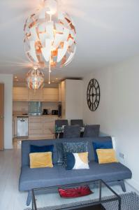 Watford Gemini Hurst في واتفورد: غرفة معيشة بها أريكة زرقاء وثريا