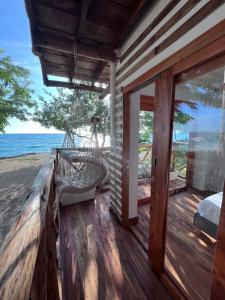 a porch with a hammock on the side of a house at Thani Ecobeach Barú in Playa Blanca