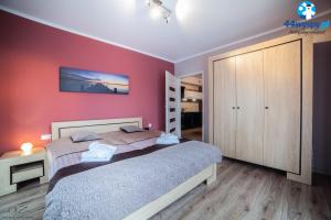 a bedroom with a bed and a red wall at Four Seasons Aquamarina in Świnoujście
