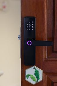 a black door with a green leaf sticker on it at EE's Surfer's House - Seaview, 3 min walk to beach in Batu Ferringhi