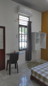 KaranganyarにあるBabemhomeのベッドルーム1室(ベッド1台、デスク、窓付)