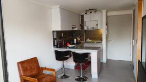 a kitchen with a counter and two bar stools at Viña Parque Urbano in Viña del Mar