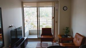sala de estar con silla y ventana grande en Viña Parque Urbano, en Viña del Mar
