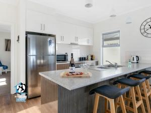 een keuken met een koelkast en een aanrecht met een fles wijn bij Ocean & Island Views for Miles – 4BR + 2.5 Baths in Encounter Bay