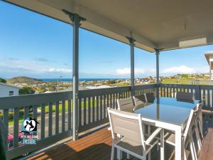 un patio con mesa y sillas en una terraza en Ocean & Island Views for Miles – 4BR + 2.5 Baths, en Encounter Bay