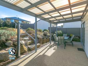 een pergola boven een patio met een tafel en stoelen bij Ocean & Island Views for Miles – 4BR + 2.5 Baths in Encounter Bay