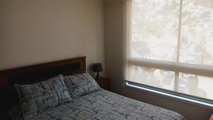 1 dormitorio con cama y ventana grande en Viña Parque Urbano, en Viña del Mar