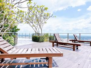 two benches sitting on a wooden deck overlooking the ocean at SilverScape Residence I Luxury 2-4 BR I 6-11 pax I Bathtub I Seaview I Infinity Pool I Jonker St I City Centre by Jay Stay Management in Melaka