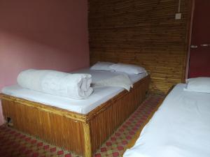 Dos camas en una habitación con toallas blancas. en Hotel new bamboo palace, en Gorkhā