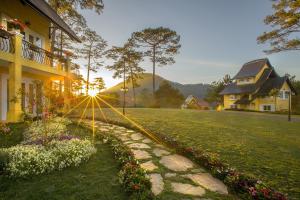 a house and a lawn with flowers in a yard at Binh An Village Resort in Da Lat