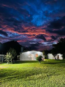 a building in a field with a cloudy sky at Casa de campo la huasteca in Monterrey