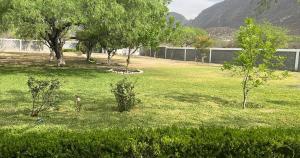 a field of grass with trees and a building at Casa de campo la huasteca in Monterrey +5 photos