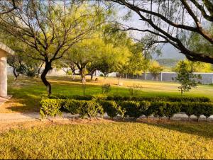 a park with trees and bushes in a field at Casa de campo la huasteca in Monterrey