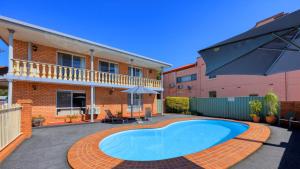 a swimming pool in front of a building at Blue Diamond Motor Inn in Dubbo