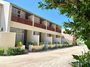 Un edificio con plantas en macetas en frente de él. en TME Retreats Dhigurah, en Dhigurah