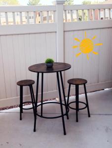 a table and two stools in front of a fence at LV Get-Away 1bdroom condo sleeps 3 in Las Vegas