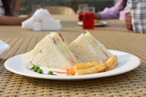 un sandwich et des chips sur une plaque sur une table dans l'établissement Purna Boutique Resort - Luxury Villa with Private Pool, à Bhimtal