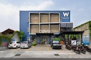 a building with cars parked in a parking lot at Cove W Suites in Jakarta
