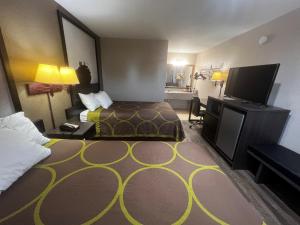 a hotel room with a bed and a flat screen tv at Super 8 by Wyndham La Marque TX/Texas City Area in La Marque