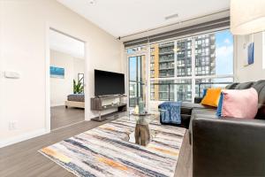 a living room with a couch and a tv at Upscale 1BR Condo - Balcony - Near Victoria Park in Kitchener
