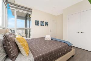 a bedroom with a bed and a large window at Upscale 1BR Condo - Balcony - Near Victoria Park in Kitchener